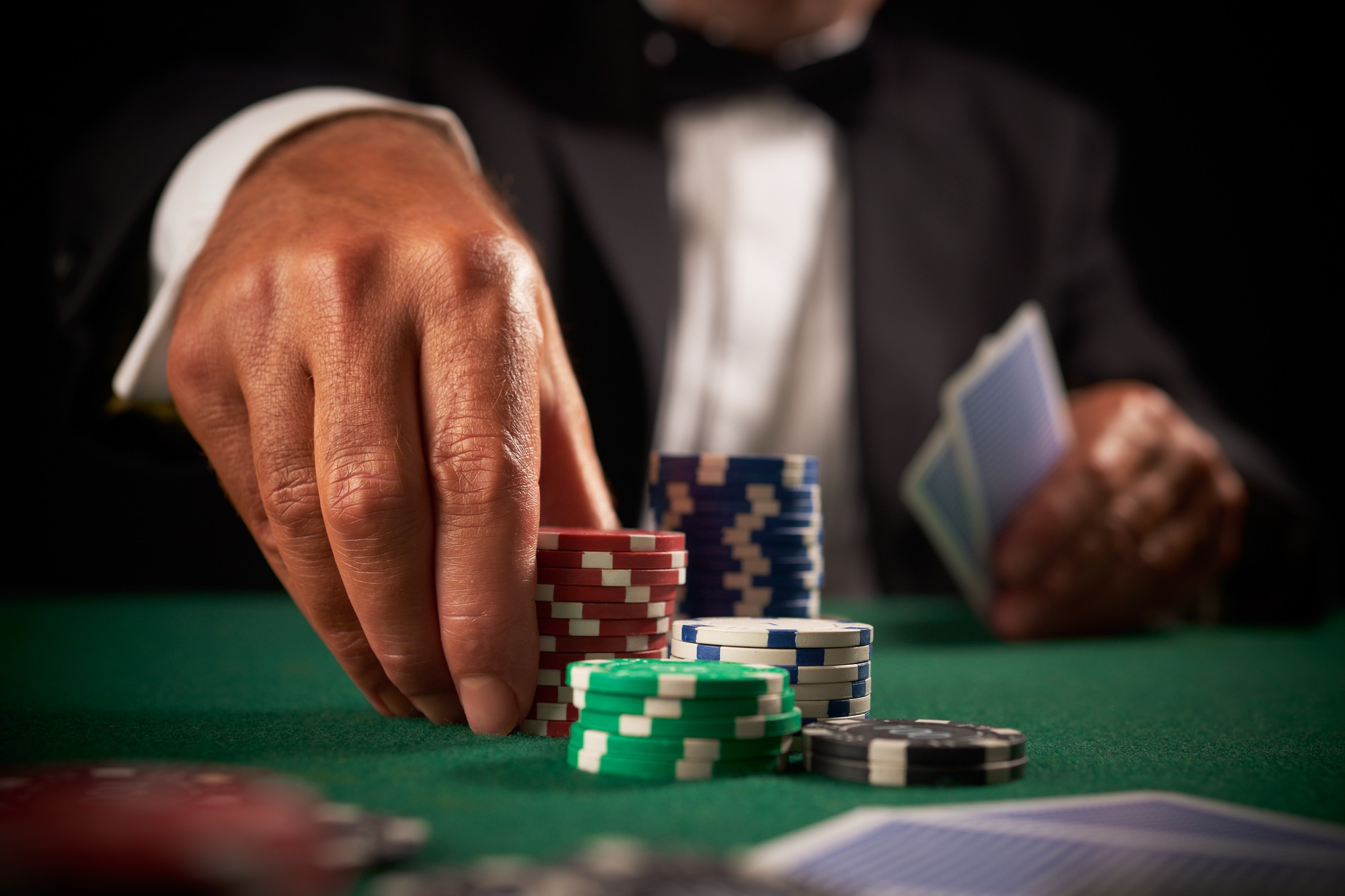 Card Player Gambling Casino Chips on Green Felt Background Selective Focus